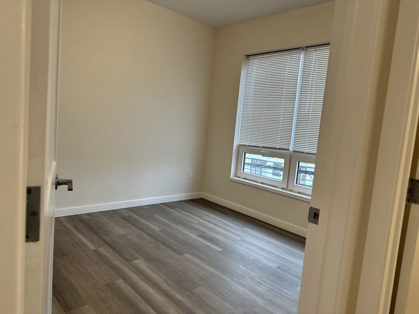 empty room with blinds and wooden floor tiles