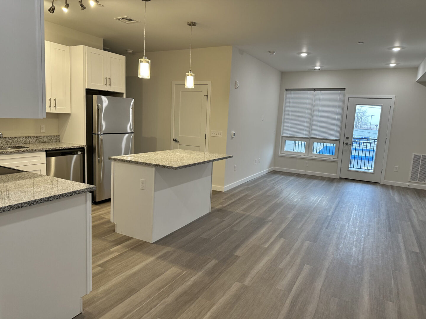 view of the living room, kitchen, and balcony entrance